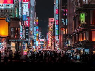 A busy street in Osaka with people crossing the street