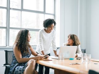 Businesswomen using laptop in meeting