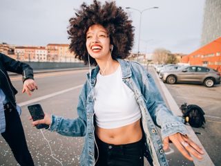Friends dancing in street to smartphone music