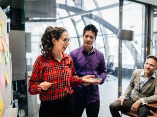 People at office discussing over sticky notes