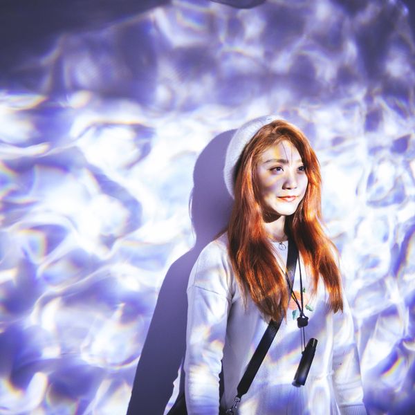 Portrait of a woman standing with blue light