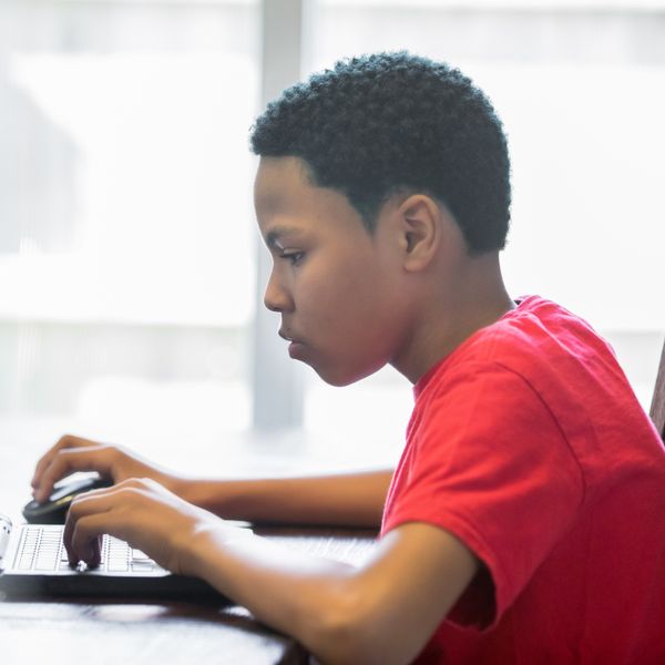 Teenage boy using laptop at home