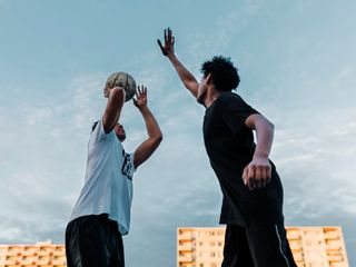 Two men playing one on one basketball game