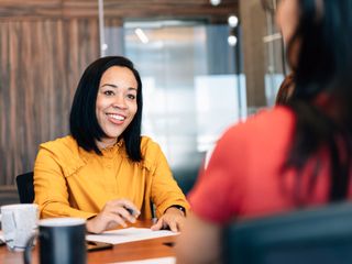 Two women talking at office