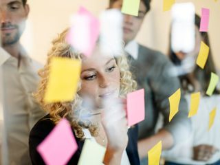 Woman in office behind glass pane with adhesive notes
