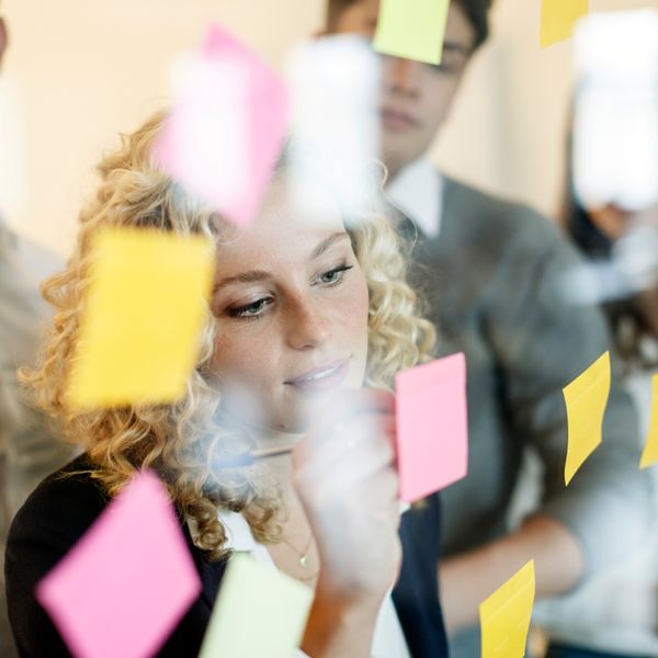 Woman in office behind glass pane with adhesive notes