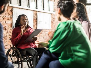 Woman in wheelchair leading group discussion