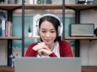 Woman with headphones doing a video conference at home